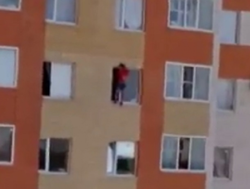 На грани смерти находится неизвестный молодой человек, свисающий из окна дома в Ставрополе